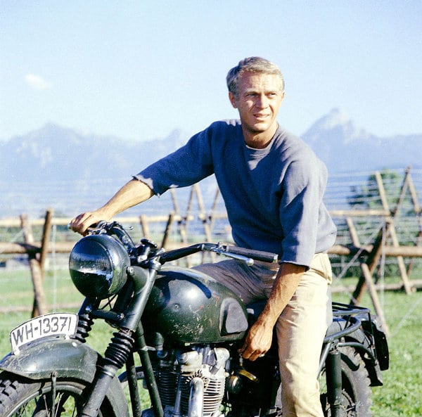 Steve mcqueen riding on motorcycle. 