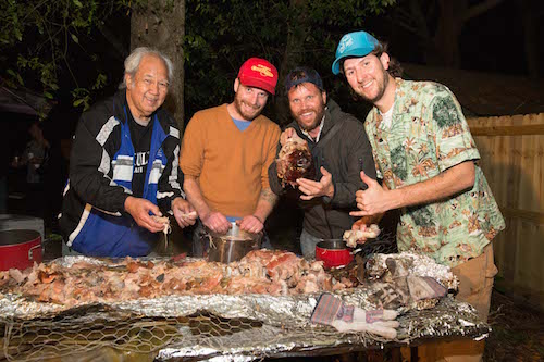 Men enjoying party with kalua pork.