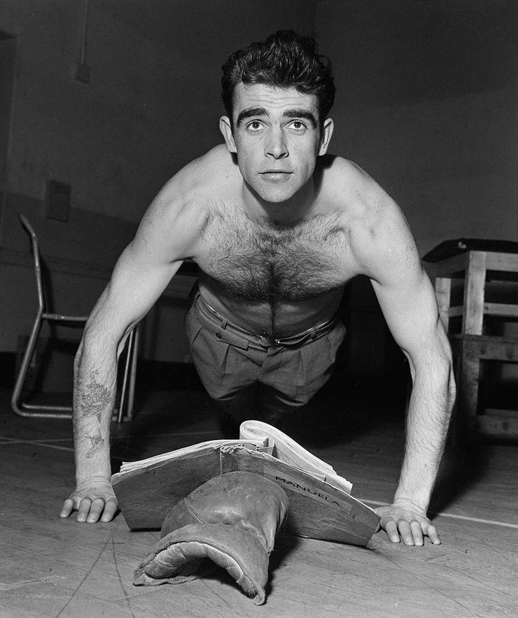Sean Connery doing push ups with the help of fitness book. 