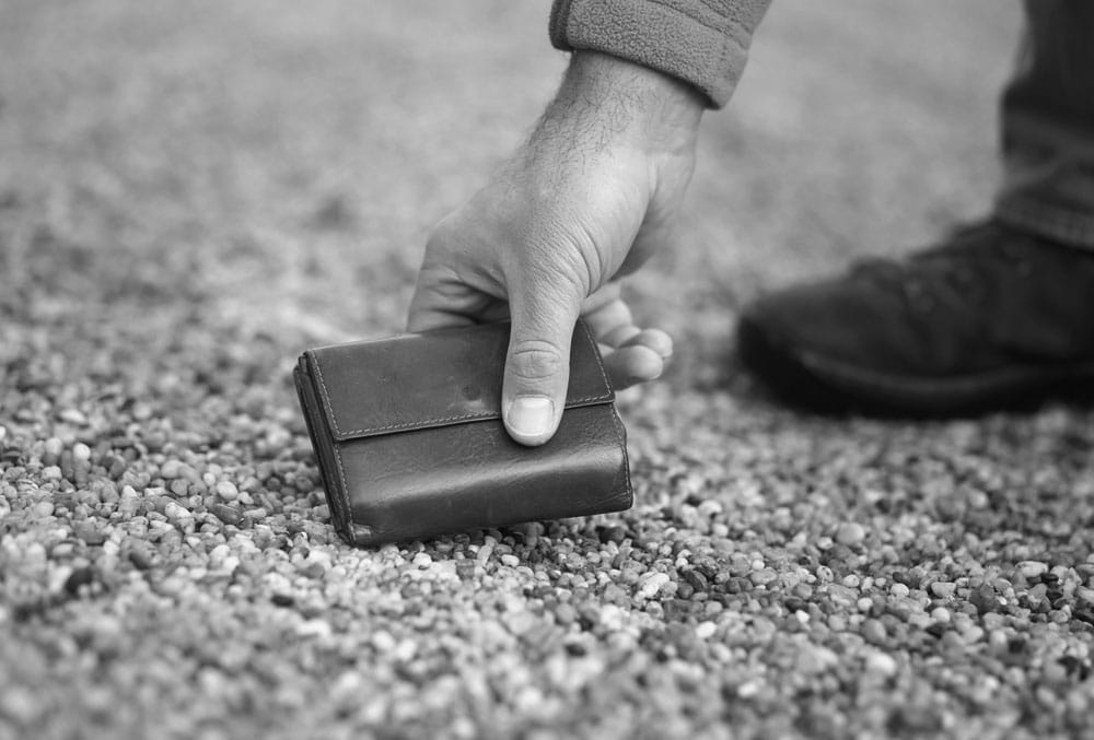 Vintage Man picking wallet up off ground.