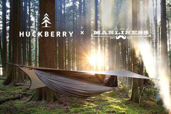 Hammock camping with rain fly in forest.