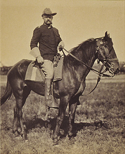 An old photograph of a man on a horse.