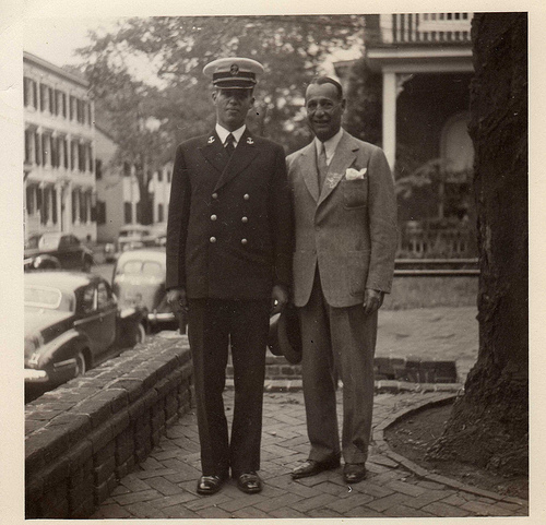 Vintage father standing with military son.