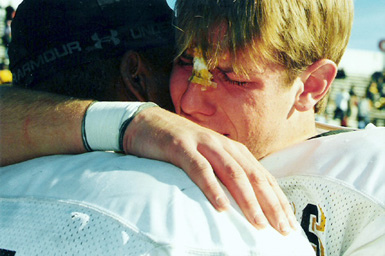 Football players crying after losing game.