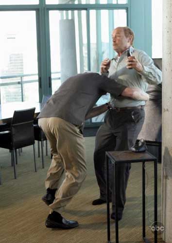 Man bending down John Locke in office.
