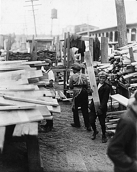 Vintage child working in lumberyard.