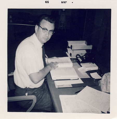 Vintage man sitting at desk with a textbook.