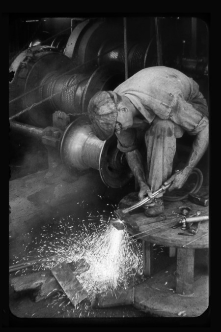 Vintage man welding in factory.