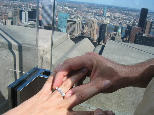 Man propose girl at skyscraper rooftop.