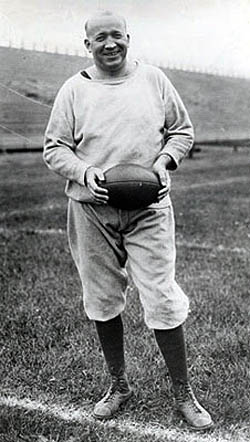 Vintage Knute Rockne standing in football ground.