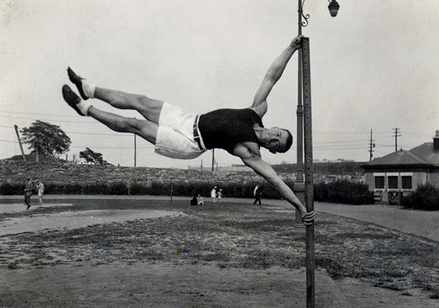 A man demonstrates his incredible fitness routine by executing a gravity-defying handstand on a pole, showcasing his mental preparations and astounding physical ability.