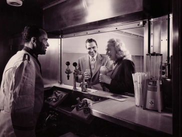 Vintage couple enjoying at soda fountain.