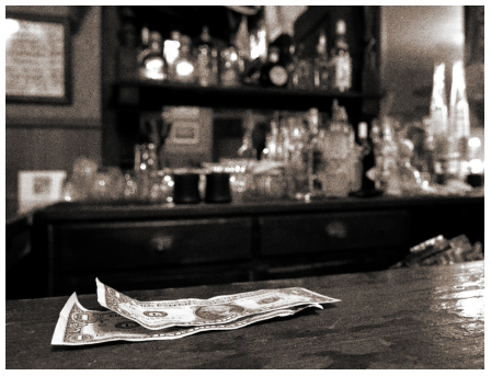 A black and white photo of money on a bar, embodying the essence of a Gentleman's Guide.