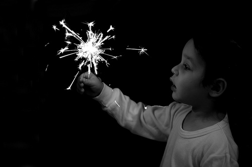 Child lightening a sparkler fireworks.