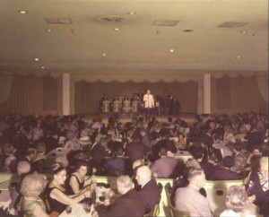 A crowd of people at a comedy club banquet, observing proper etiquette.