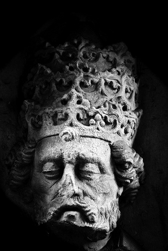 Stone statue of a king wearing crown.