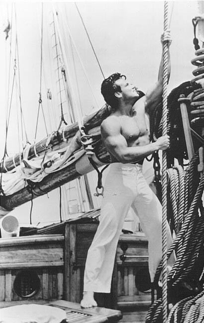 Vintage sailor pulling a rope on boat.