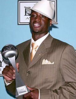 Dwayne Wade wearing suit and white hat holding espy award.