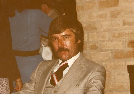 Tom McKay mustache in suit.