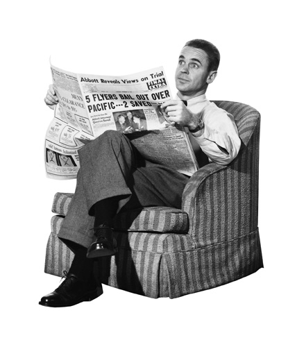 Vintage man sitting on chair and reading newspaper.