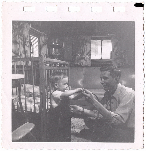 Vintage father and son playing in room.