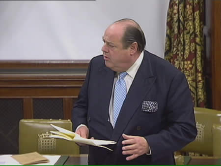 Nicholas Soames holding british parliament papers.