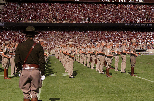 Corps of cadets in football field.