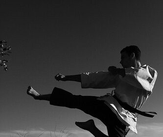 A supercharged black and white photo showcasing the spirit of a man practicing martial arts through karate.