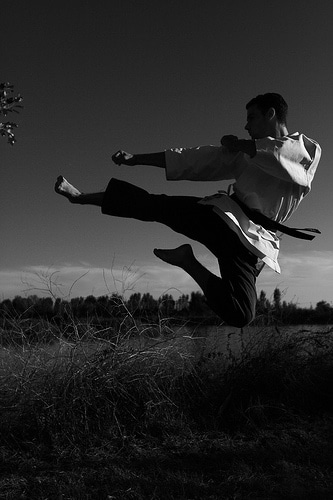 A supercharged black and white photo showcasing the spirit of a man practicing martial arts through karate.