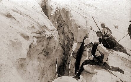 A man is climbing up a way snowy mountain.