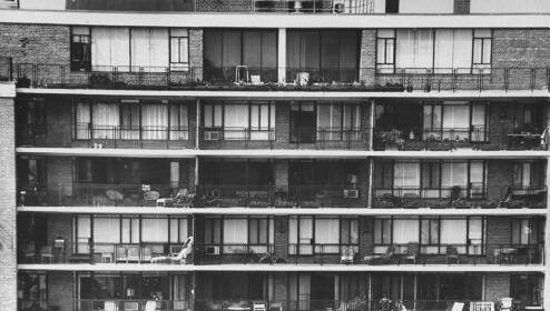 Find your first apartment with this black and white photo of an apartment building with balconies.