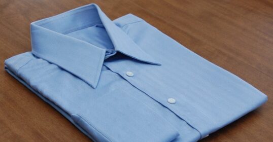 A dress shirt on a wooden table.