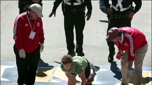 A man is kneeling on the ground, delivering a powerful Manvotional inspired by Robert Service's 