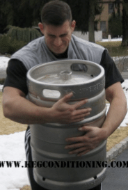 Man lifting keg for fitness routine.