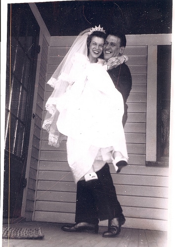 Vintage man carrying his wife in the room.