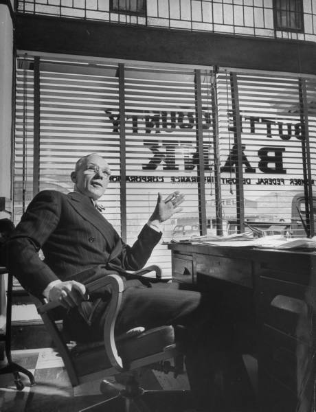 Vintage banker sitting on the chair in his office.