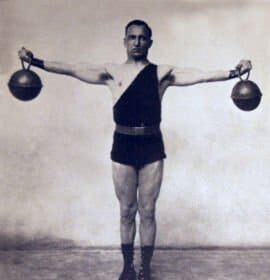 An old photo of a man engaging in a workout with two kettlebells.