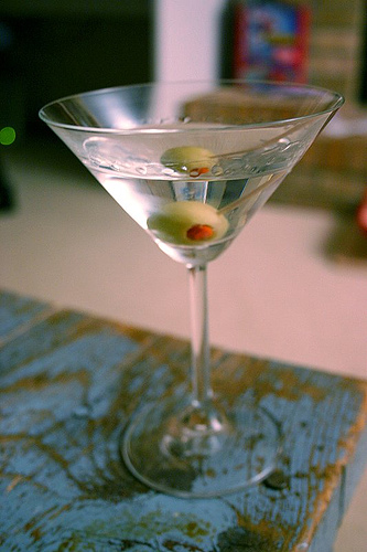 Martini cocktail in the glass with olives.