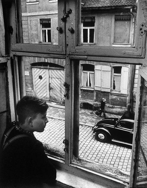 Vintage boy looking out window.