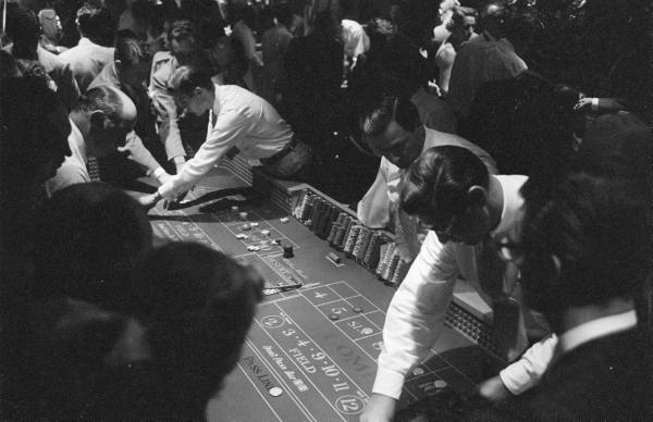 Vintage men gambling craps table casino game.