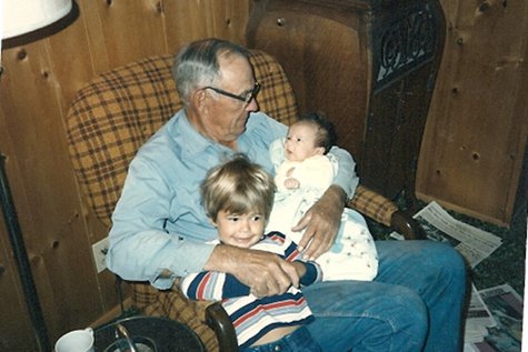 Grandpa with small grandchildren in chair 1970s.