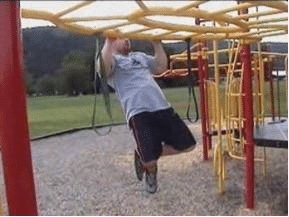 Man doing pull up on Swingset playground workout.