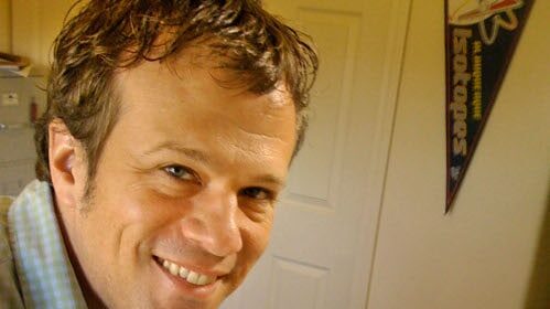 An artist sitting at a desk, working on a cartoon illustration for his job.