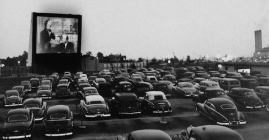 A black and white photo of cars parked in a parking lot is an essential addition to any man's movie library.