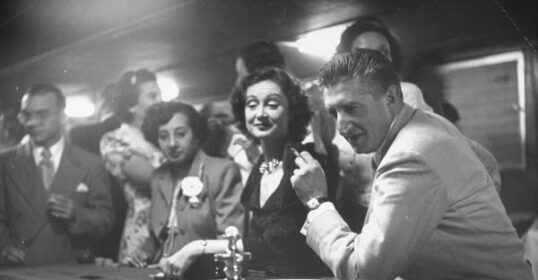A man and woman playing Roulette at a casino.