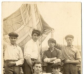 A group of John Brookes and his friends posing on a boat, exuding manliness.