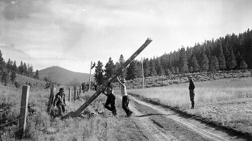 A black and white photo depicting a group of men on a dirt road, making a difference.