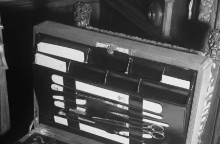 An artistic black and white photograph of a briefcase containing various papers.