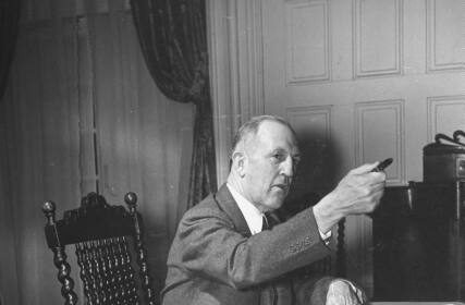A decisive man in a suit sitting at a desk.