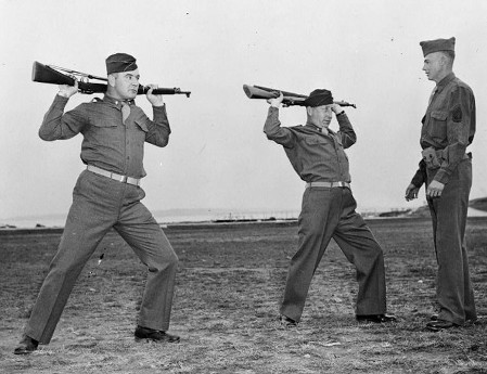 James Braddock and Joe Gould geting training with a rifle in their hands.